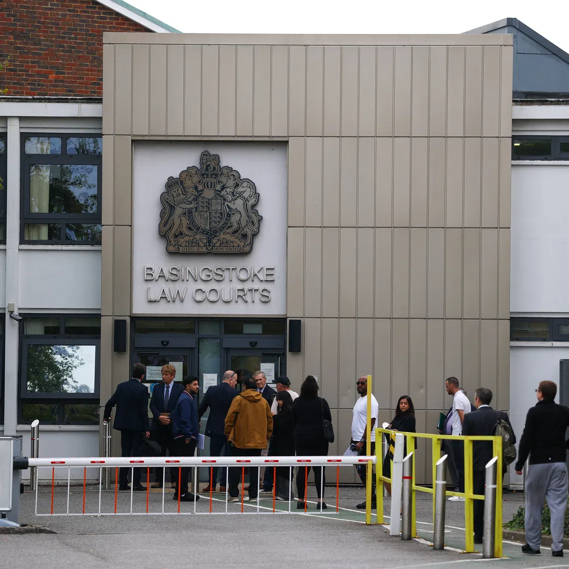 People gather outside Basingstoke Magistrates Court, on the day Daniel Thomas, known as Danny Tommo is appearing via videolink, charged with criminal damage to a small boat while an emergency responder was aboard, in Basingstoke, Britain, September 25, 2026. REUTERS/Hannah McKay
