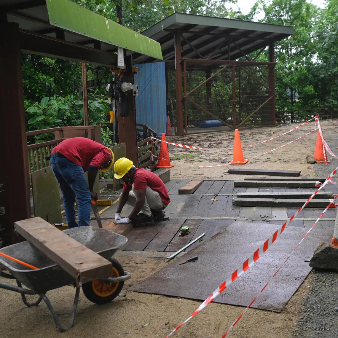 Workers patch up a hole in a crossing of a sluice gate at Sungei Buloh where a man and two-year-old daughter fell, on January 26, 2023.