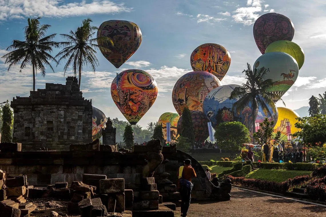 Visitors watching hot air balloons being launched during celebrations to mark Vesak Day at Ngawen Temple complex in Muntilan, Central Java, on May 12, 2024.