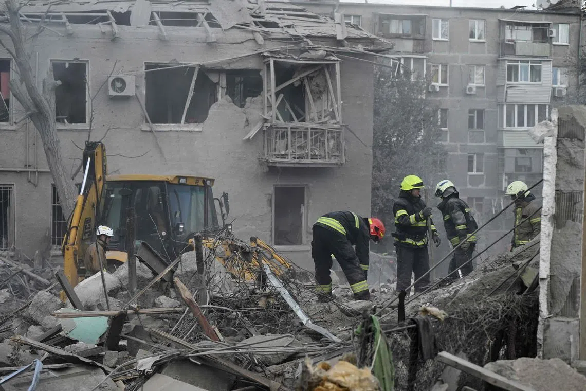 Ukrainian rescuers clear debris at the site of a Russian missile strike in Dnipro, eastern Ukraine, on Oct 26.