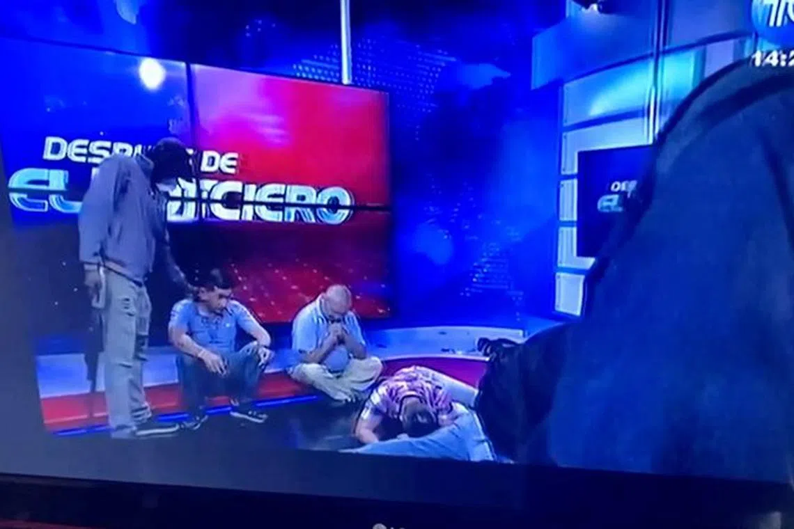 Workers lie on the floor as hooded and armed people take over a tv studio of Ecuador's TV station TC during a live broadcast, in this still image of a Reuters' recording of the affair of TC signal channel, in Guayaquil, Ecuador, January 9, 2024. Reuters Tv/via REUTERS ECUADOR OUT. NO COMMERCIAL OR EDITORIAL SALES IN ECUADOR. NO RESALES. NO ARCHIVES