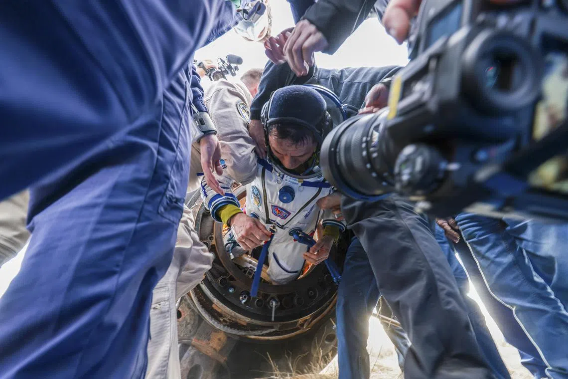 Roscosmos State Space Corporation specialists helping NASA astronaut Frank Rubio exit the Soyuz MS-23 spacecraft just minutes after it landed in a remote area near Zhezkazgan, Kazakhstan on Sept 27.