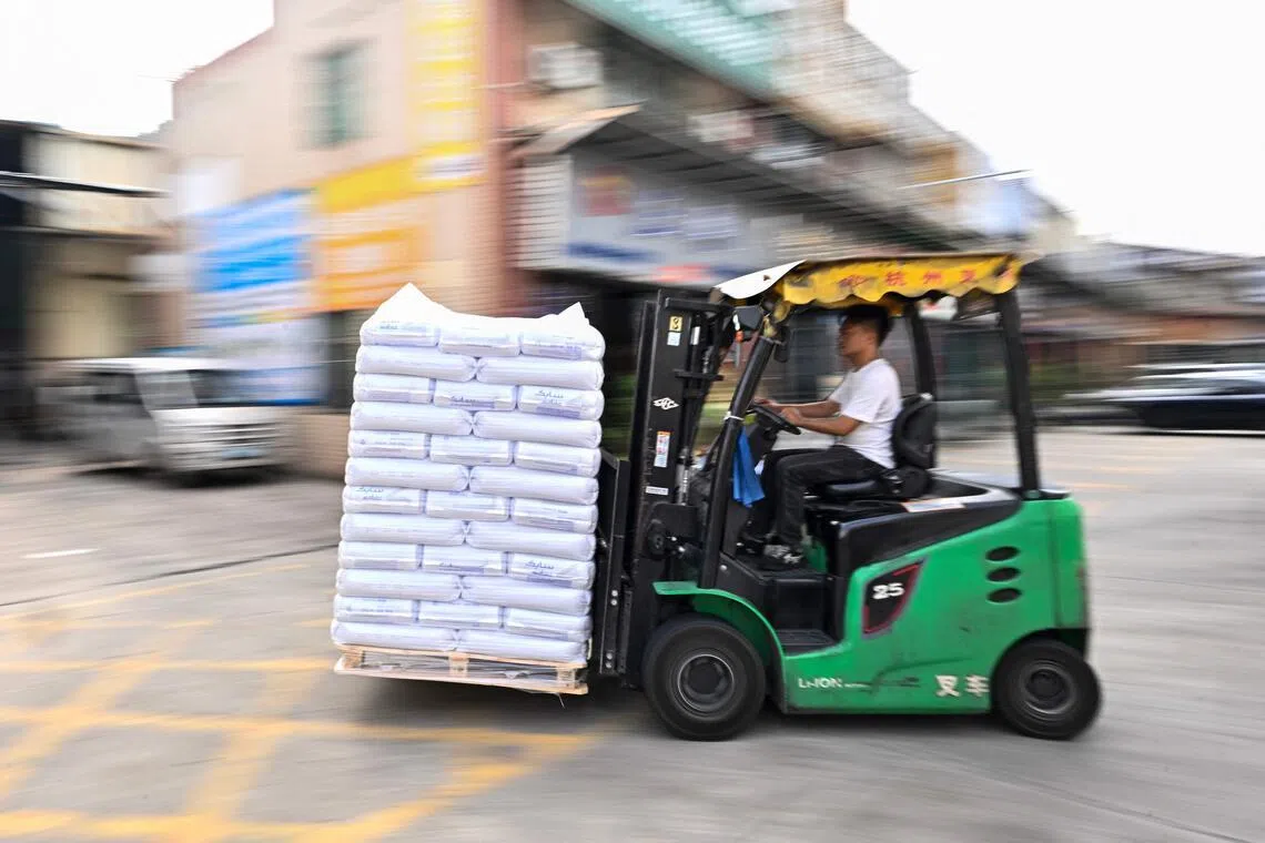 An employee drives a forklift as he unloads bales from a truck at the Zhangmutou Plastic Raw Material Market in Dongguan, in southern China’s Guangdong province, on April 29. 