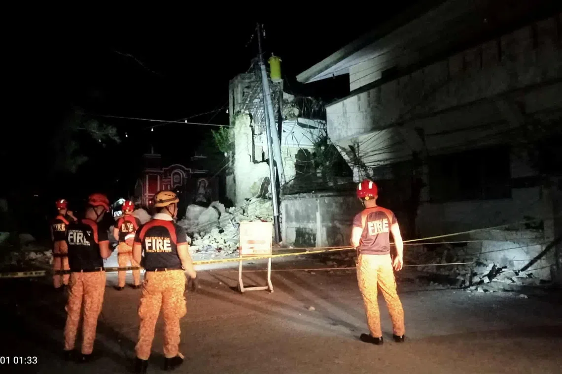 Rescue personnel stand in front of a damaged structure following a 6.9-magnitude earthquake, in Daanbantayan, Cebu Province, Philippines, October 1, 2025. Municipality of Daanbantayan/Handout via REUTERS