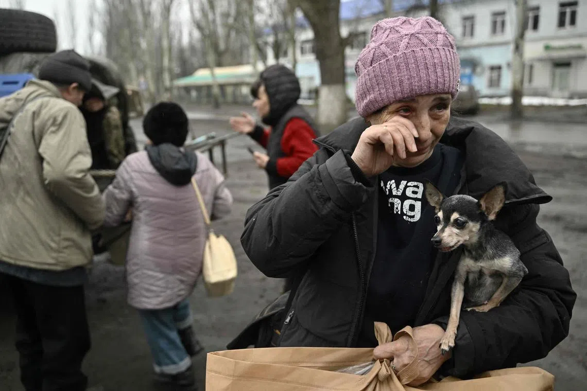 A woman, who gave her name as Lyuba, was crying as she clutched her shivering chihuahua, Margot.