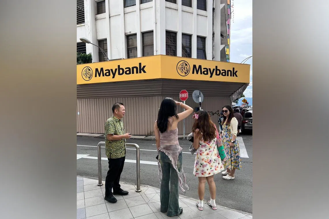 Kota Kinabalu MP Chan Foong Hin (left) visited Gaya Street to speak to some of the tourists taking photos at the spot.