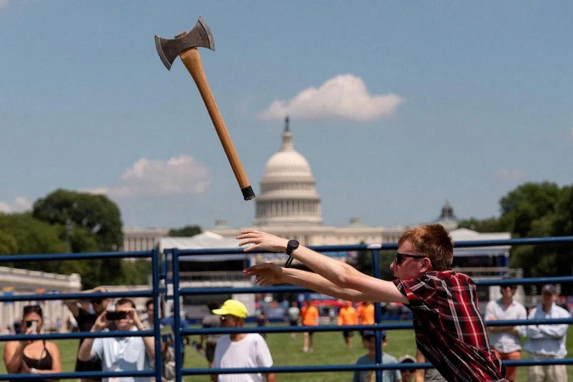 An axe-throwing competition takes place at The Great American State Fair on the National Mall in Washington DC.