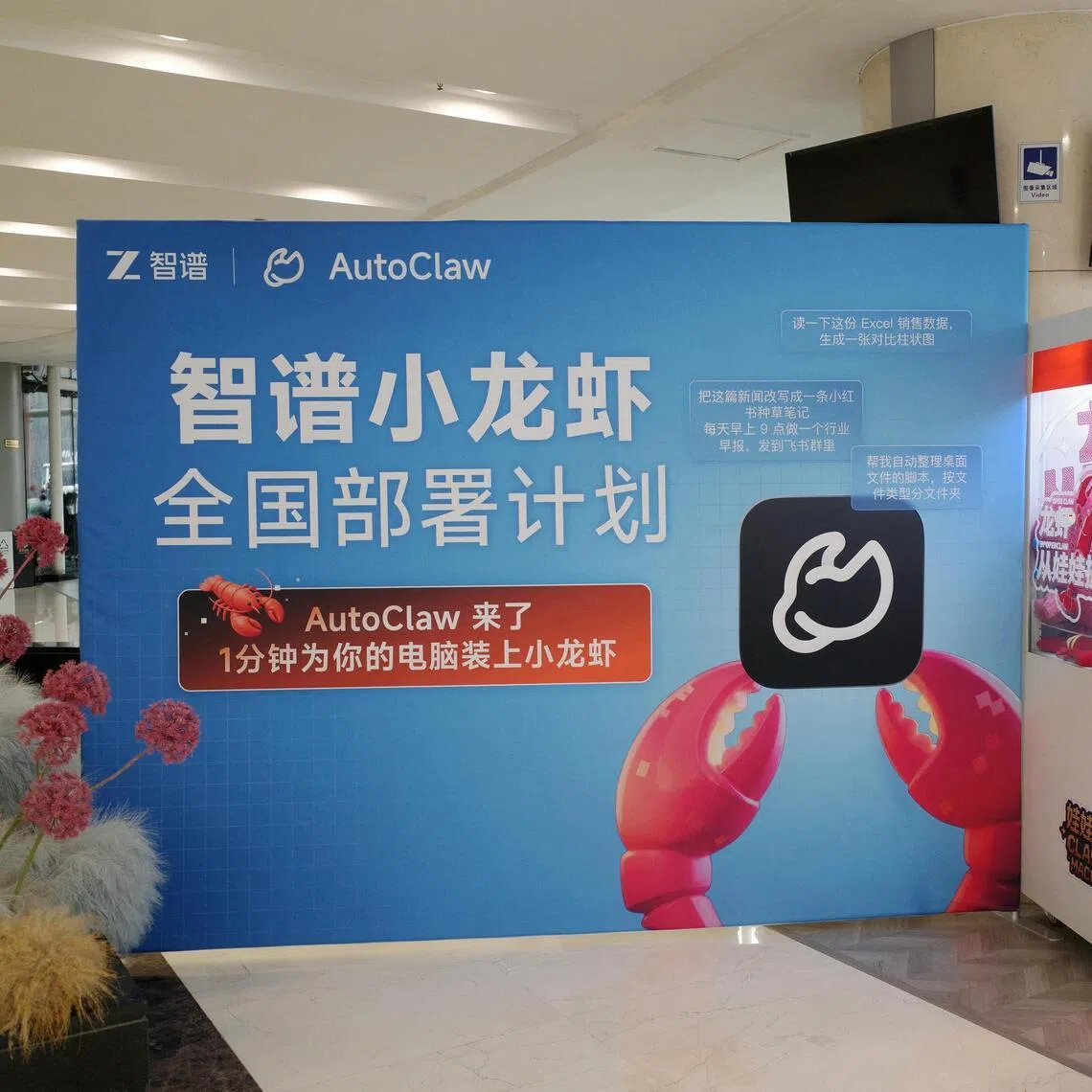 People stand in front of a claw machine filled with lobster-shaped plush toys during a setup session for AutoClaw, a local version of the AI agent OpenClaw developed by Zhipu.