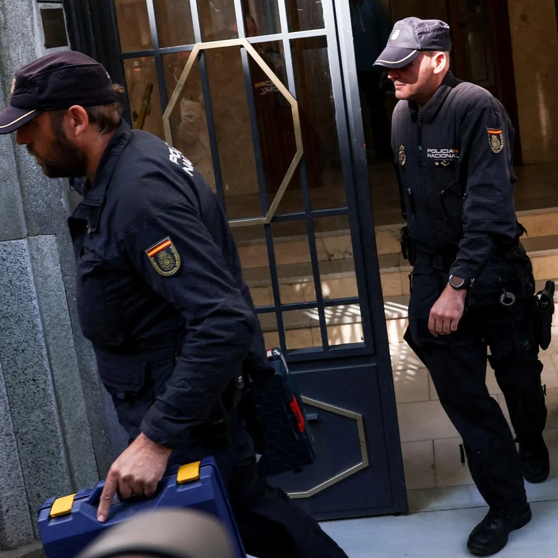 Police officers carry cases from the office of former Spanish Prime Minister Jose Luis Rodriguez Zapatero, who, according to the country's High Court, is being investigated for alleged influence peddling and related crimes, in Madrid, Spain, May 19, 2026.