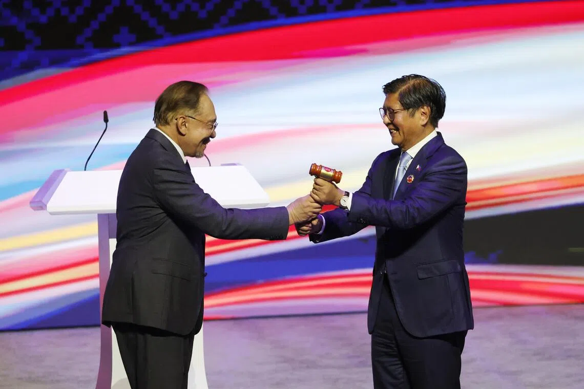 Malaysia's Prime Minister Anwar Ibrahim (left) passes the ceremonial gavel to Philippine President Ferdinand Marcos Jr. during the handing over ceremony of the Asean chairmanship in Kuala Lumpur, Malaysia, on Oct 28, 2025.