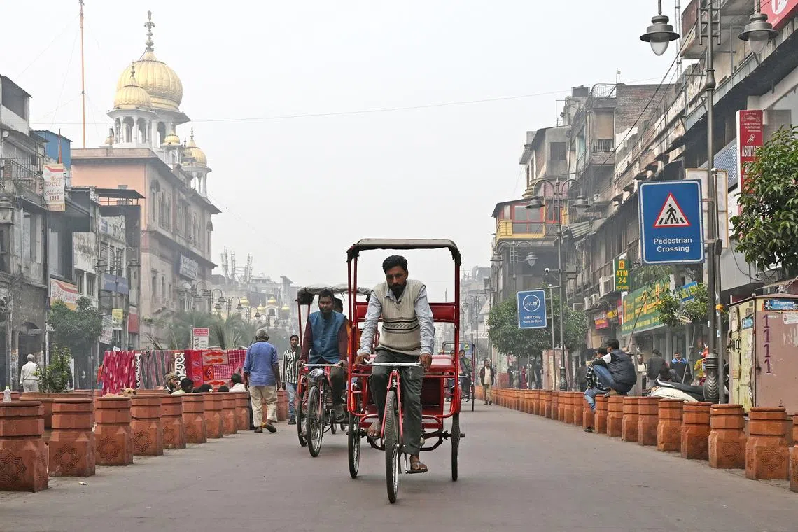 Mr Rizwan (centre), who pedals a rickshaw tricycle, looking for customers amid dense smog in New Delhi on Nov 30.