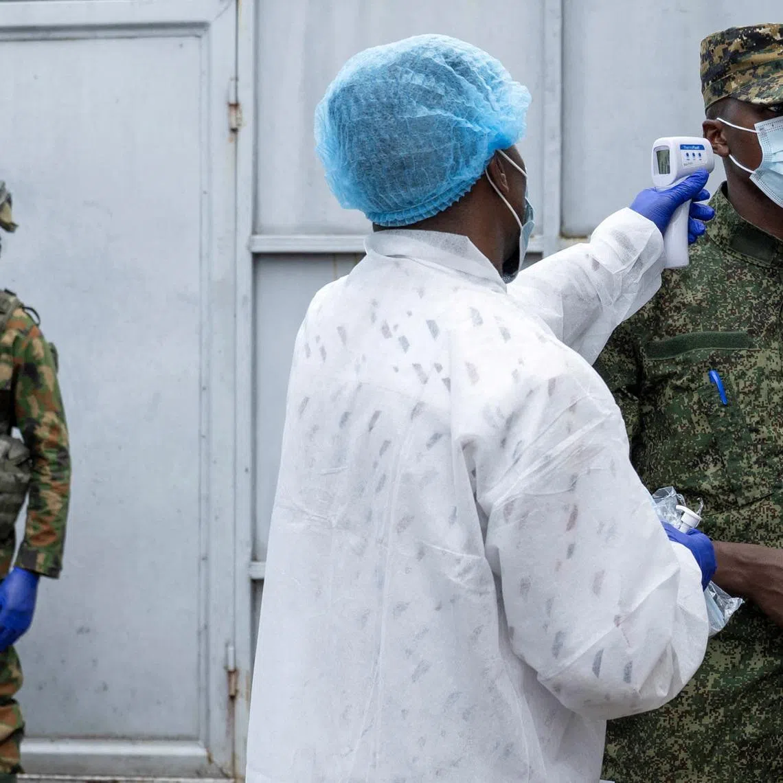 FILE PHOTO: A health worker takes the temperature of an M23 rebel at the entrance to the Rodolphe Merieux Laboratory, National Biomedical Research Institute (INRB), where samples from suspected Ebola cases are examined, as part of the response to the epidemic in Goma, North Kivu province of the Democratic Republic of Congo, May 19, 2026. REUTERS/Arlette Bashizi/File Photo