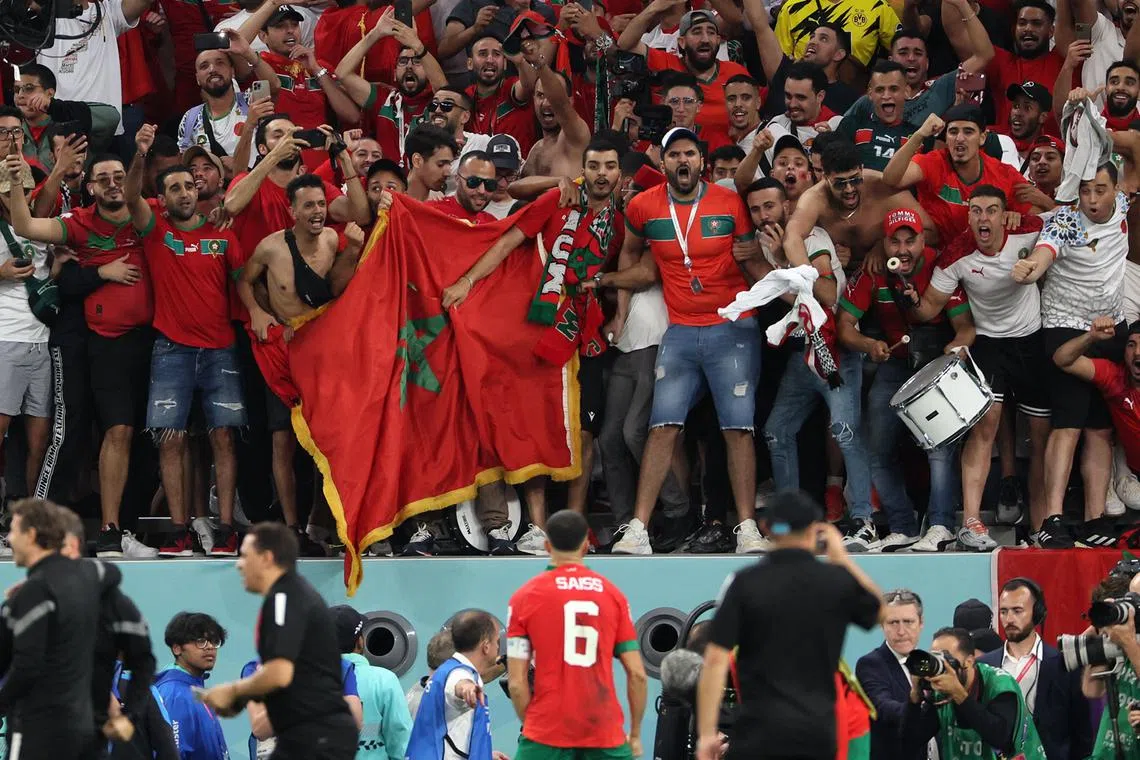 Morocco's defender #06 Romain Ghanem Saiss (C) celebrates with supporters winning the Qatar 2022 World Cup round of 16 football match between Morocco and Spain at the Education City Stadium in Al-Rayyan, west of Doha on Dec 6, 2022. 