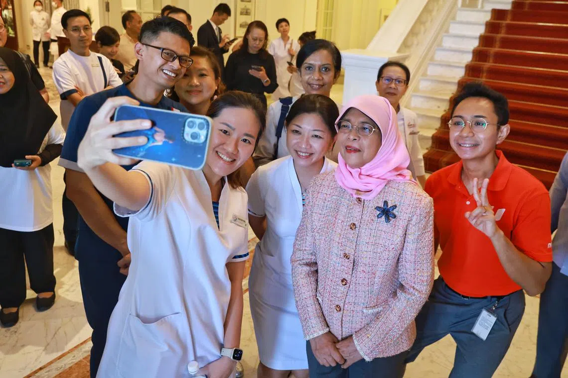 President Halimah Yacob with healthcare sector workers from the Healthcare Services Employees' Union at the Istana on Apr 26.