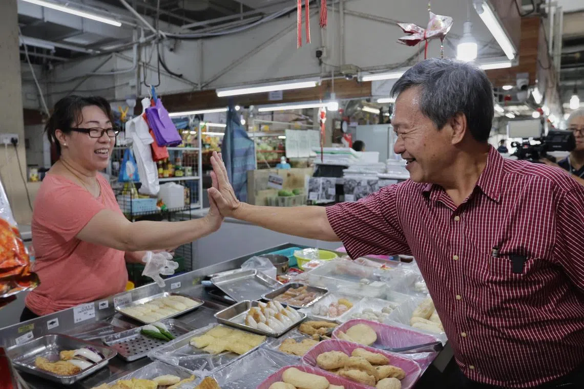 Mr Tan Kin Lian greeting a vendor at the wet market at Kopitiam Square on Aug 14.