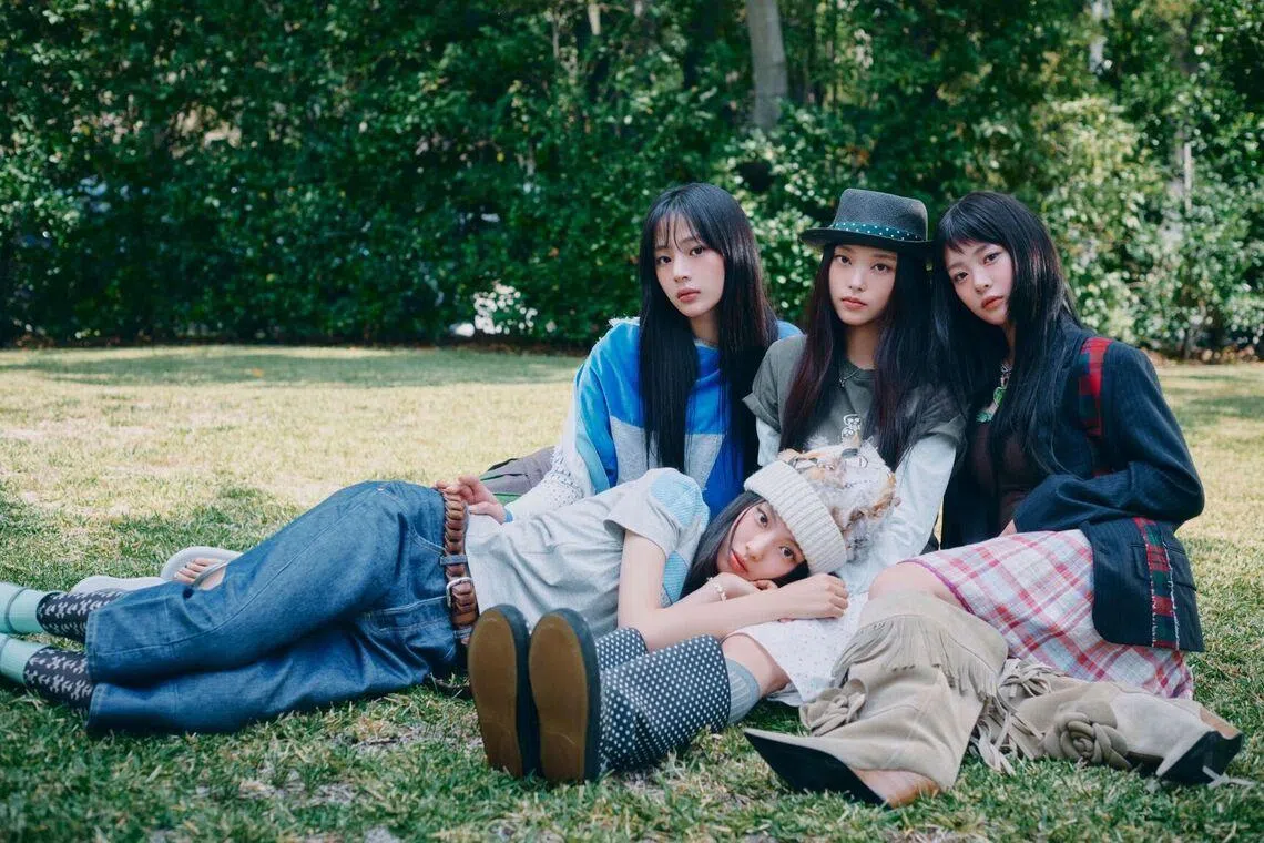 NewJeans members (seated, from left) Minji, Haerin, Hanni and Hyein (lying down) in the group’s latest promotional campaign.