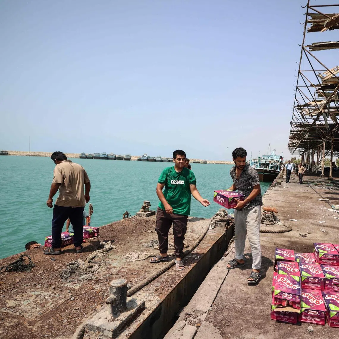 Iranian men off load food stuff close to the port’s damaged storage and warehousing facilities following a US military strike earlier in the week on Kuhestak, Sirik County, in Iran’s southern Hormozgan province on Sept 6.