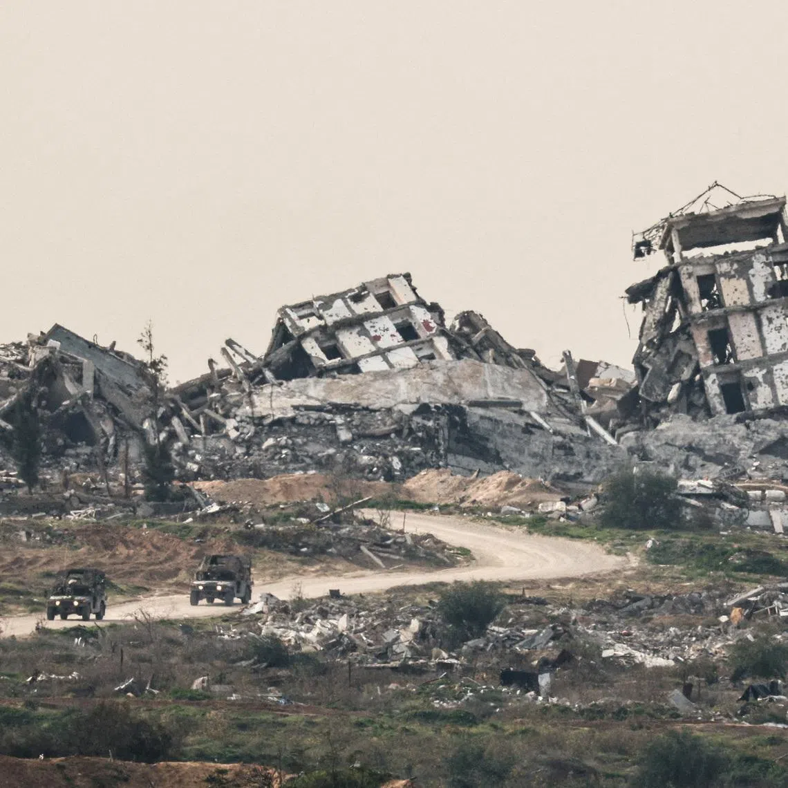 FILE PHOTO: Israeli military vehicles drive past destruction in Gaza, as seen from the Israeli side of the Israel-Gaza border in southern Israel, January 21, 2026. REUTERS/Amir Cohen/File Photo