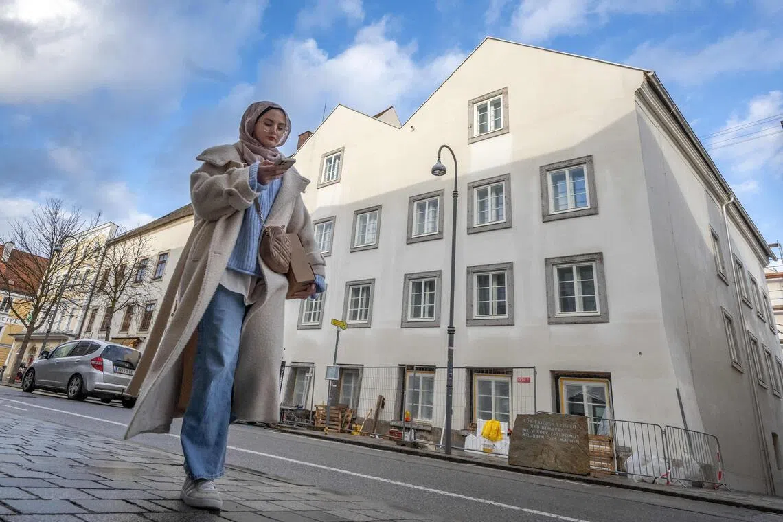 A woman walks past the birth house of former German dictator Adolf Hitler that is turned into a police station, in Braunau am Inn, Austria, on Feb 17. 