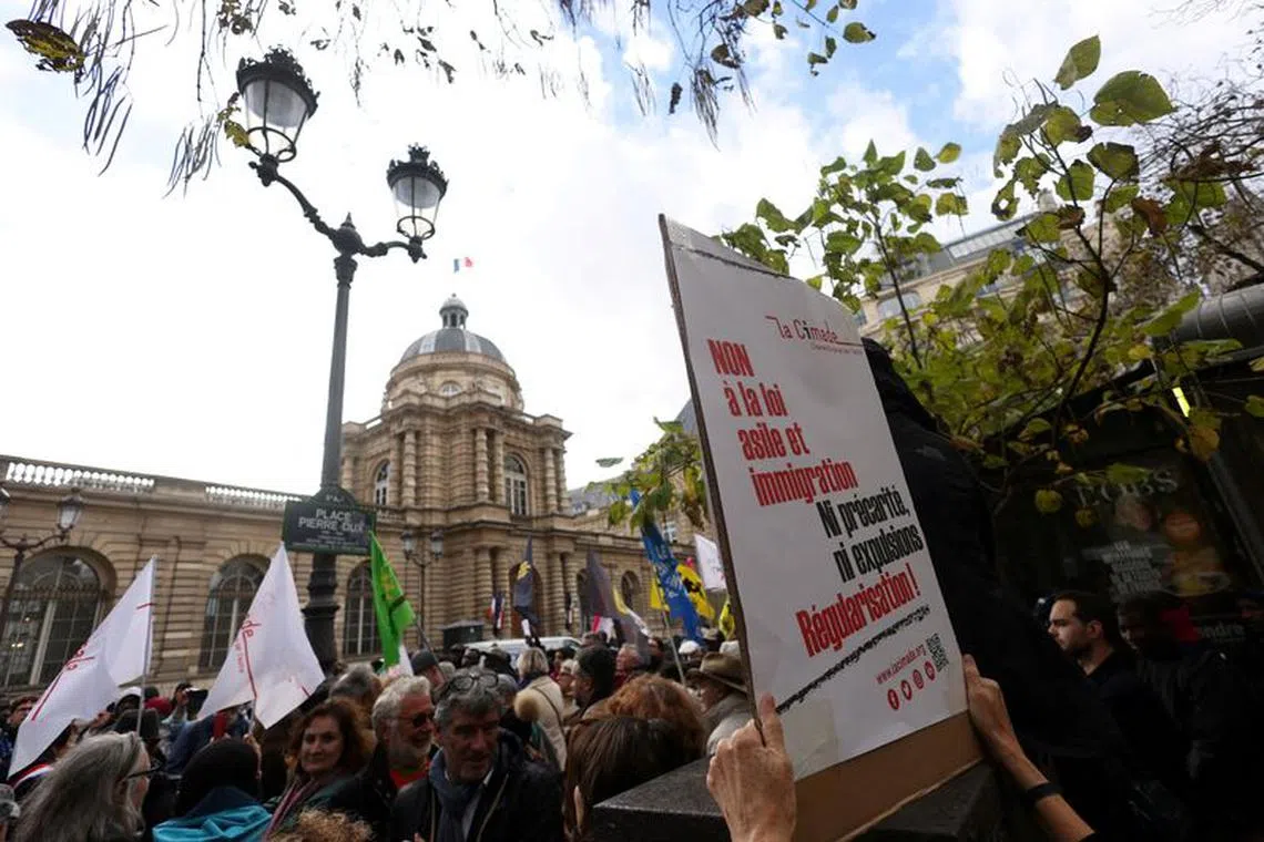 FILE PHOTO: People attend a demonstration before the start of debate on an immigration bill at the French Senate in Paris, France, November 6, 2023. The placard reads \"No to the asylum and immigration law. Neither precariousness nor expulsion, Regularization !\". REUTERS/Claudia Greco/File Photo