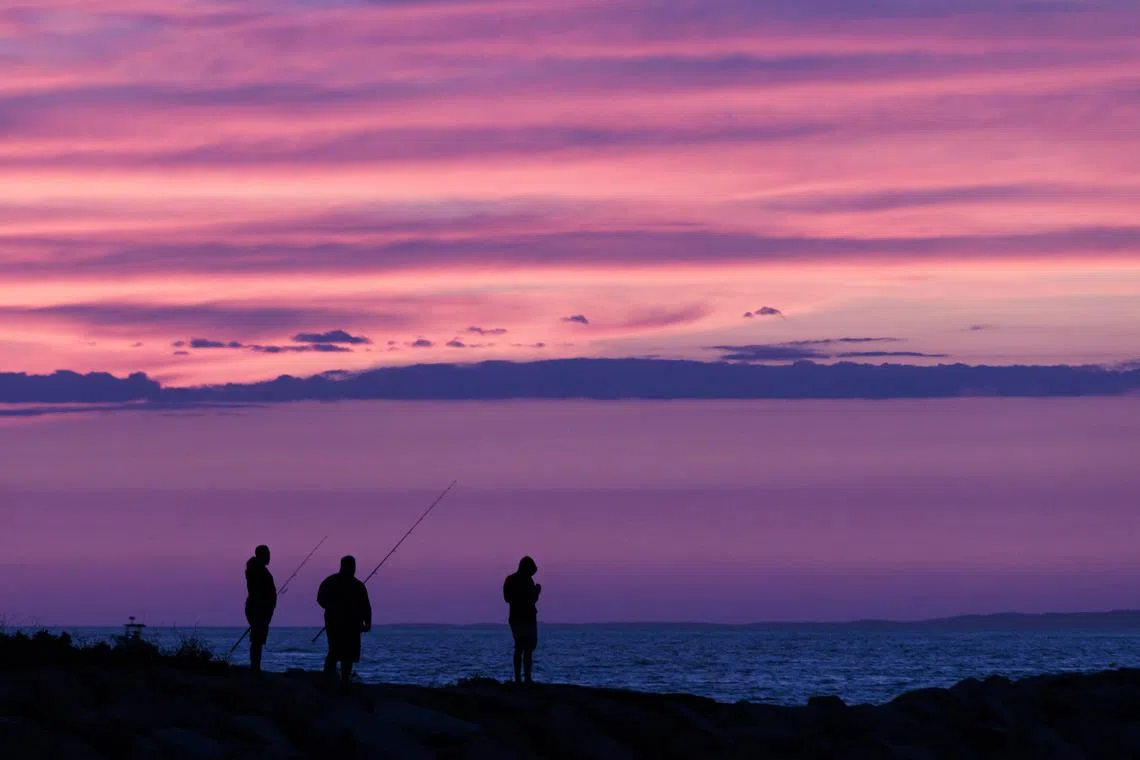 People fishing as the sun sets at Lobsterville Beach in Aquinnah, Massachusetts, USA, Aug 30.