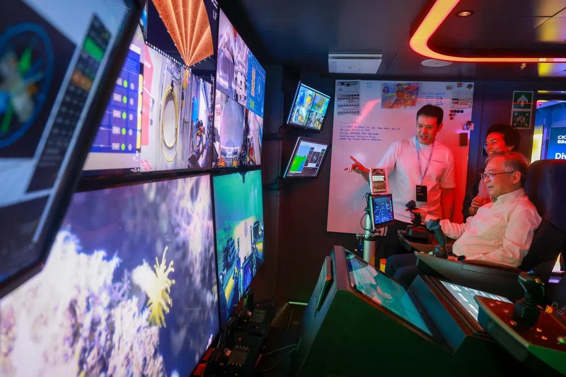 Deputy Prime Minister Gan Kim Yong trying out a virtual submersible simulator during the OceanX Summit.