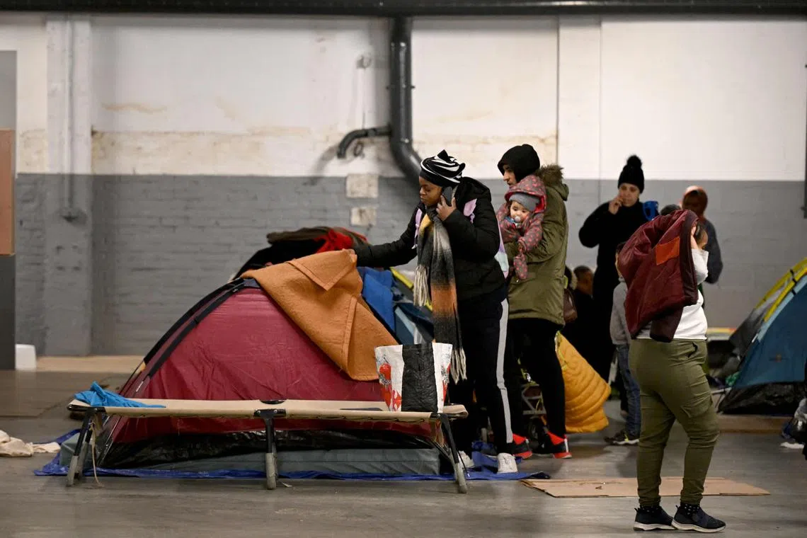 People in administrative difficulties, including migrants and asylum seekers, settle in tents installed in a parking lot transformed by the humanitarian association Utopia 56 into a temporary night shelter, near the Arc de Triomphe in Paris.