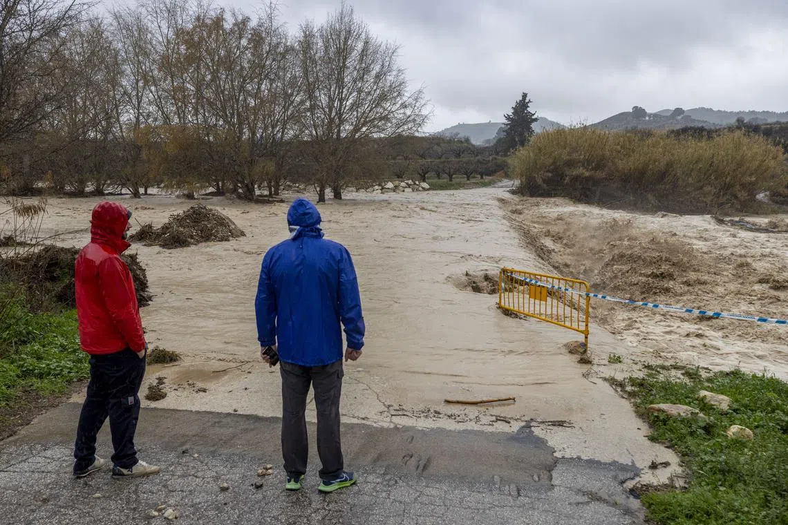 Residents look at a flooded area after the river Argos overflowed due to heavy rains in Murcia, southeastern Spain, on March 6.