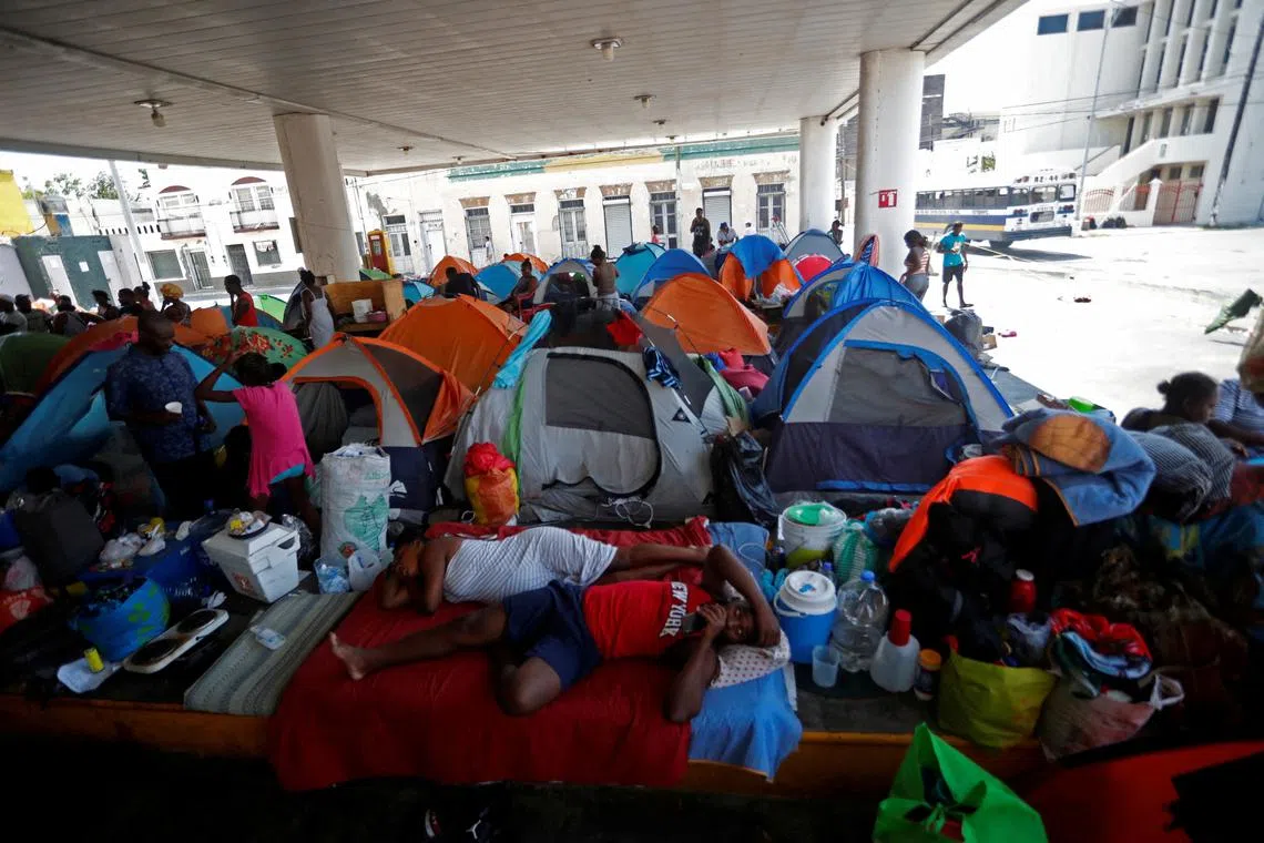 Haitian asylum seekers set up camp in an abandoned gas station in Matamaros, Mexico, while they wait to attempt to cross into the US.