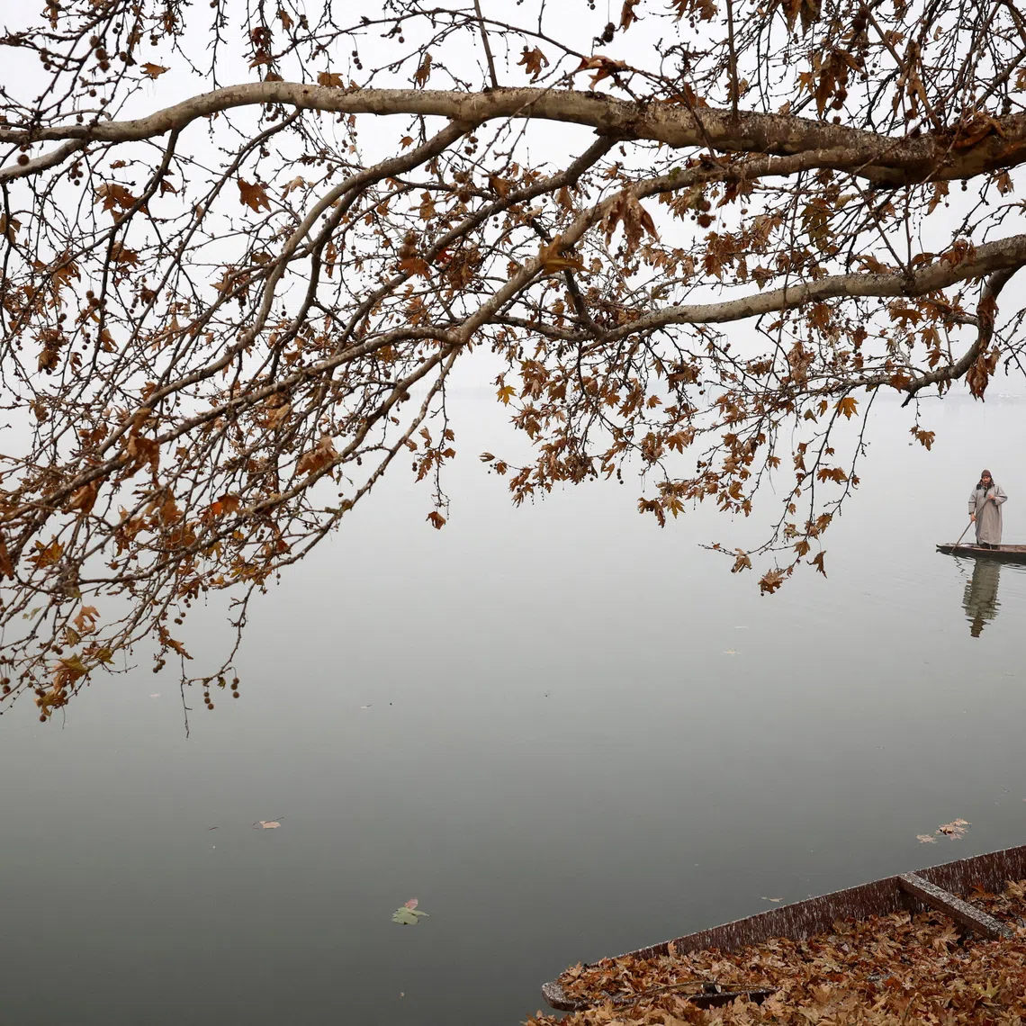 A man rowing his boat on a cold morning across Dal Lake in Srinagar, Indian-administered Kashmir, on Dec 2, 2025. 