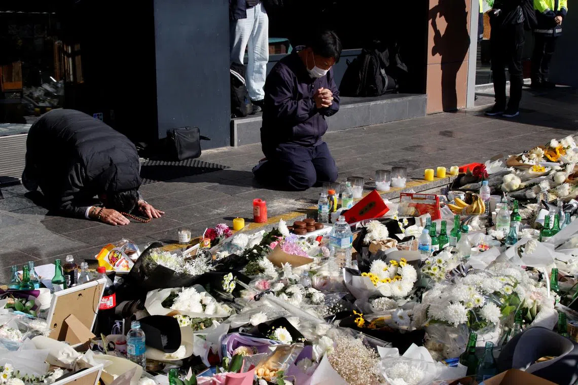 FILE PHOTO: People pay respects near the scene of a crowd crush that happened during Halloween festivities, in Seoul, South Korea, November 2, 2022. REUTERS/Heo Ran/File Photo