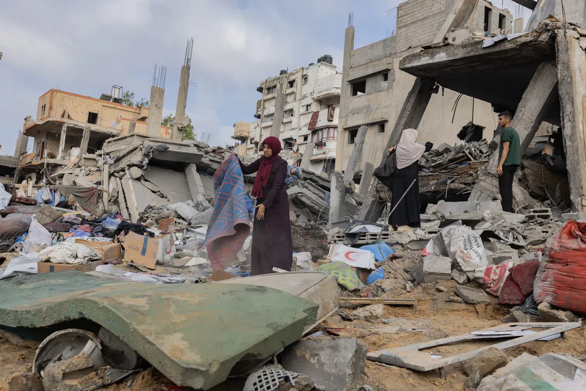 People salvage what they can from the wreckage of a building in Gaza City after an Israeli airstrike on July 30.