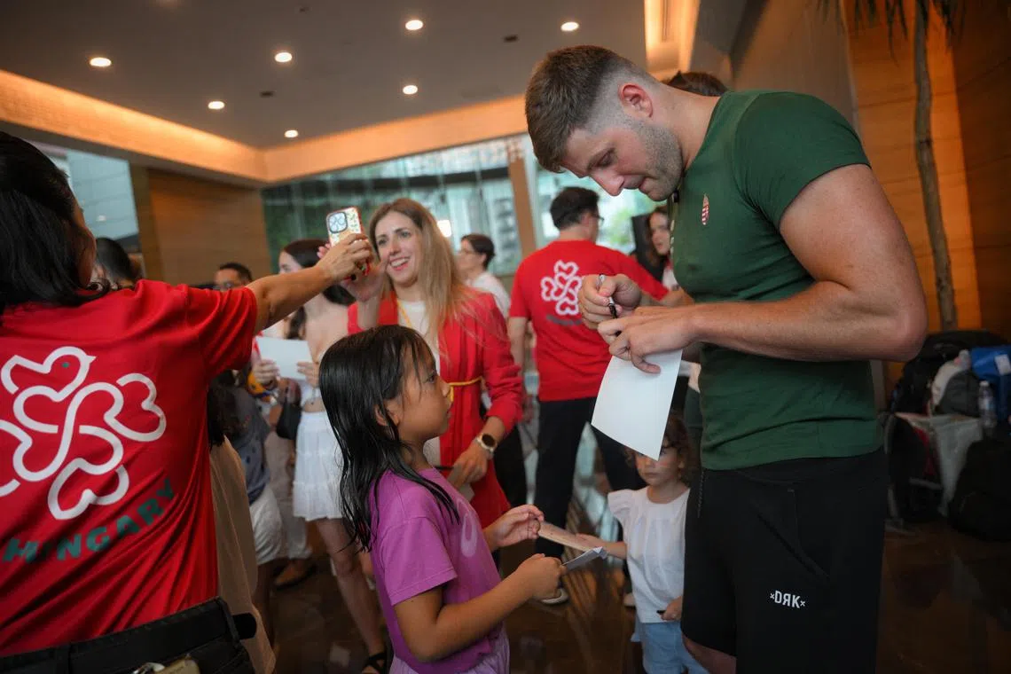 Krisztian Manhercz, the captain of the Hungarian Men's Water Polo Team, signs autographs for fans during a meet and greet at the Chinese Swimming Club on July 9, 2025.