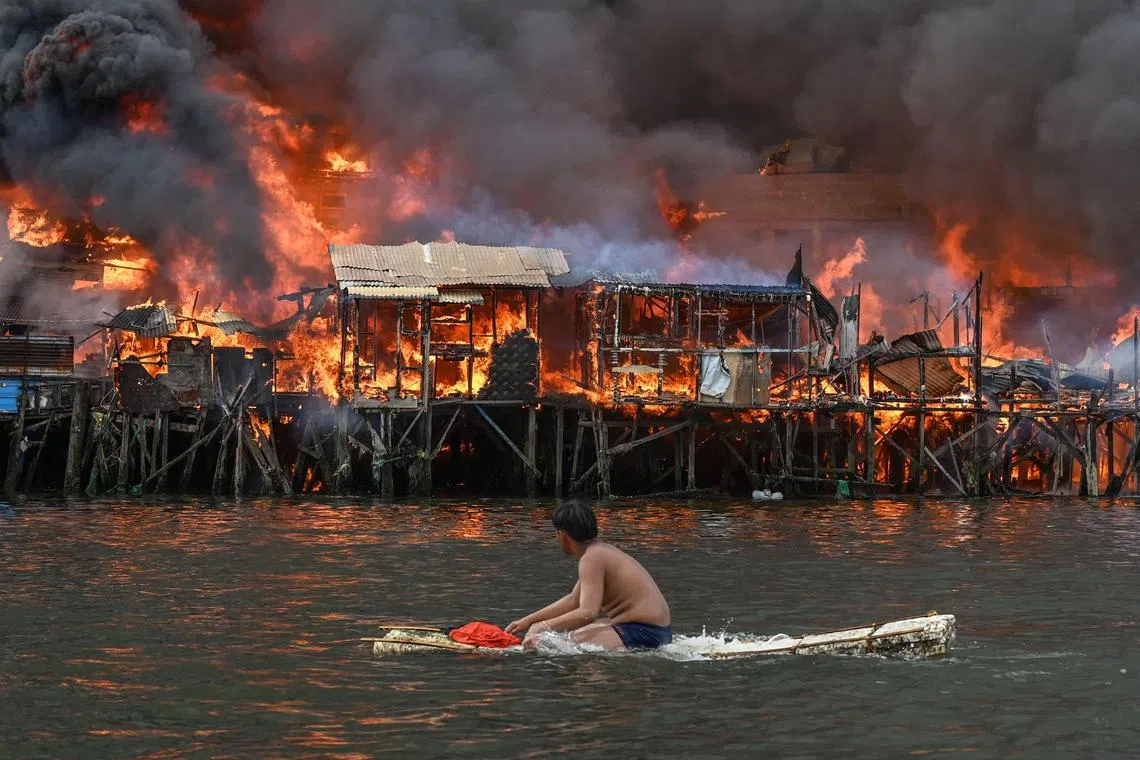 Raging orange flames and thick black smoke billowed into the sky as a fire tore through hundreds of houses in a densely built slum in the Philippine capital, Manila, on November 24, 2024.
