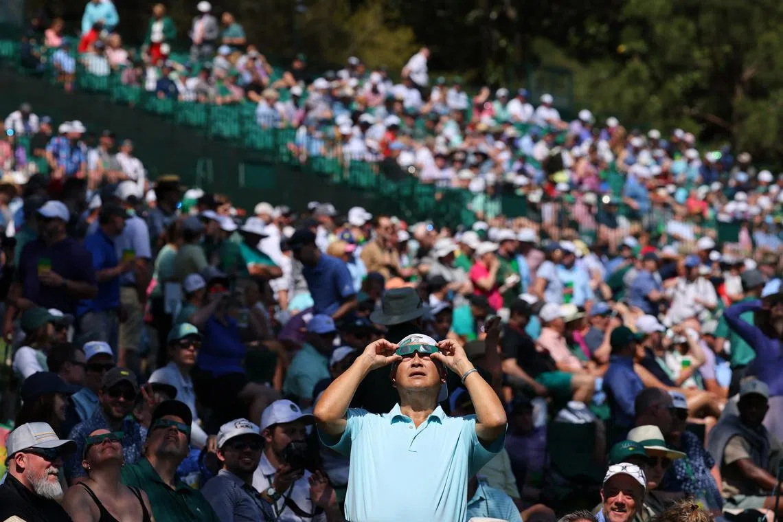 People watching the solar eclipse from the Augusta National Golf Club in Georgia on April 8, 2024.