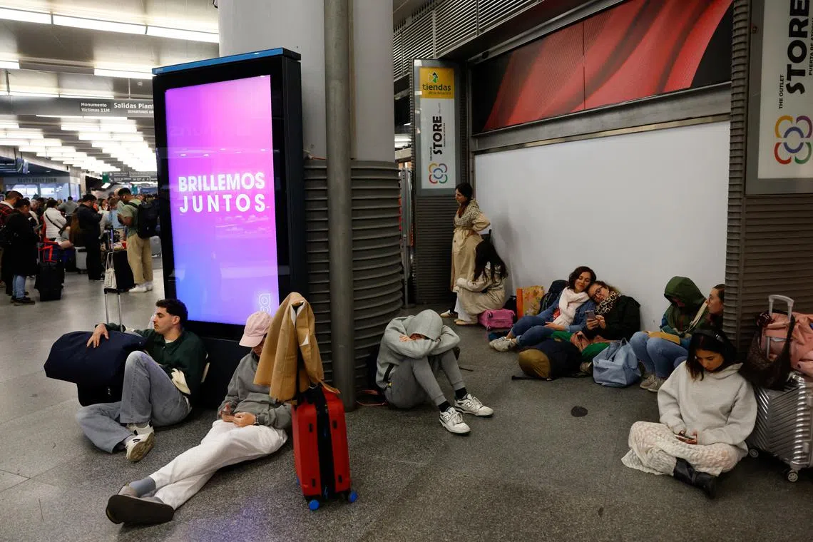 Passengers wait to be given access to their trains after cable stolen from a high-speed train line between Madrid and Andalusia caused delays at Atocha station in Madrid, Spain, May 5, 2025. REUTERS/Susana Vera