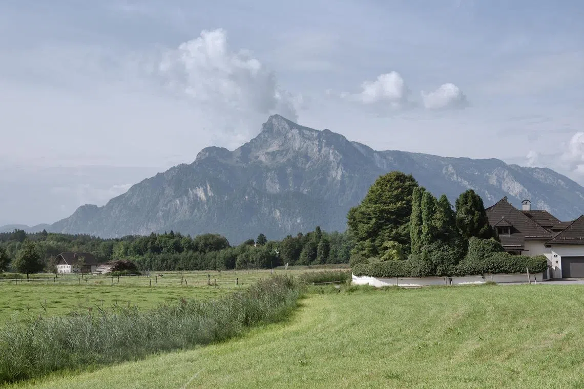 Untersberg, the iconic mountain from the The Sound of Music, rises behind meadows and farmhouses in Salzburg, Austria, Aug. 20, 2025.