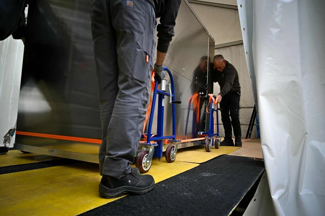 Workers move a fake Bayeux Tapestry box into a special conservation tent in Bayeux, northern France.
