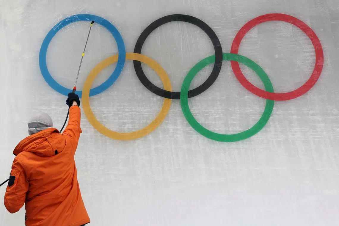An ice maker installs a sub-glacial Olympic logo ahead of the Beijing 2022 Winter Olympics at Yanqing National Sliding Centre in Yanqing, China, January 28, 2022. REUTERS/Edgar Su/File Photo