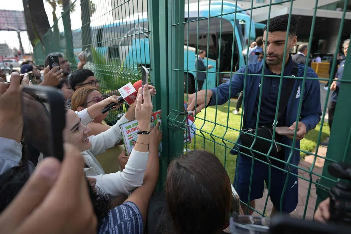 Journalists' and fans gather as Iran players sign autographs upont the team's departure for Seattle where it will play against Egypt in Tijuana, Mexico, on June 24, 2026, as part of the 2026 World Cup football tournament. (Photo by Guillermo Arias / AFP)