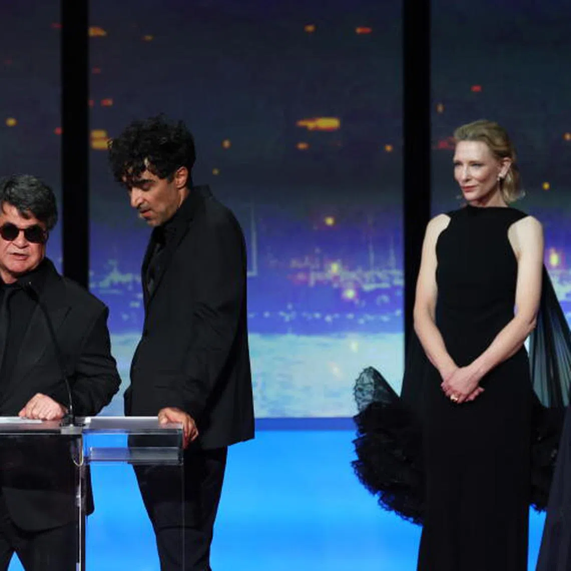 epa12132936 Iranian director and screenwriter and producer Jafar Panahi (L) speaks on stage after winning the Palme d'Or for the film "Un simple accident" (A Simple Accident) watched by Juliette Binoche (R) and Cate Blanchett (2-R) during the closing and awards ceremony of the 78th annual Cannes Film Festival, in Cannes, France, 24 May 2025. The film festival runs from 13 to 24 May 2025. EPA-EFE/MOHAMMED BADRA