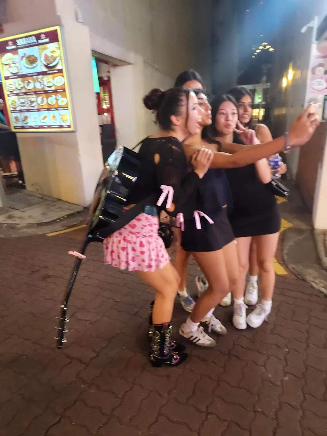 Peace (with guitar) taking a photo with fans at Boat Quay.