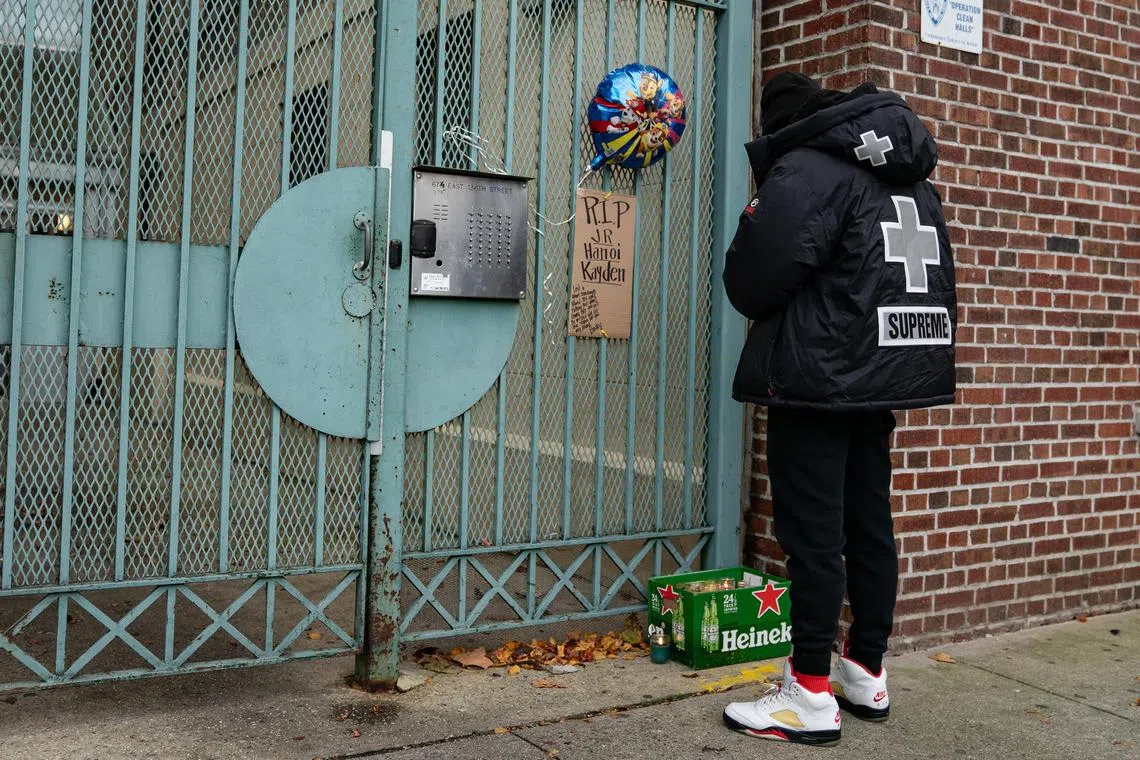 A makeshift memorial outside the apartment building where a five-year-old boy and his parents were found dead.  
