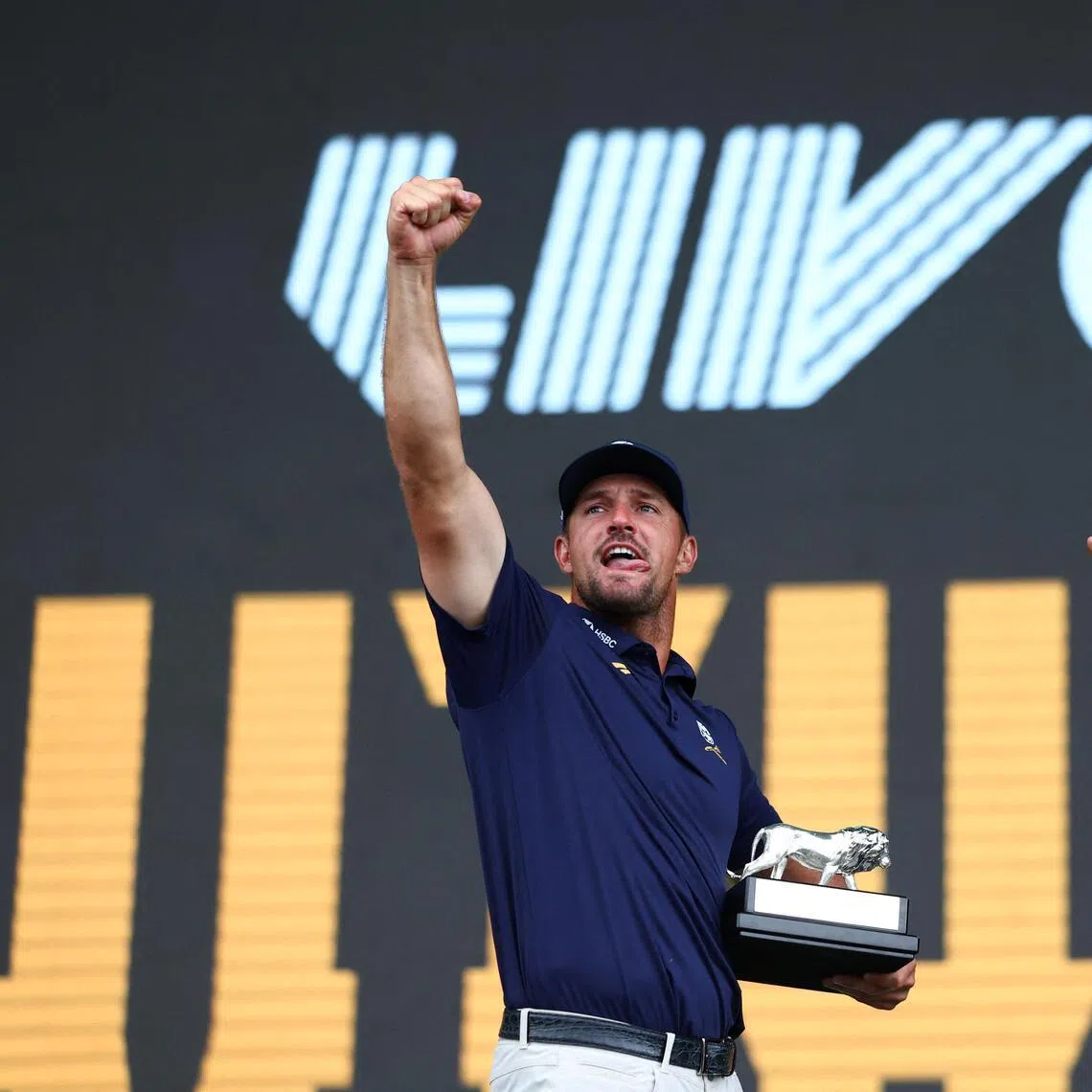 Bryson DeChambeau celebrating after winning LIV Golf South Africa on March 22, after being presented the trophy by South African President Cyril Ramaphosa  (right).