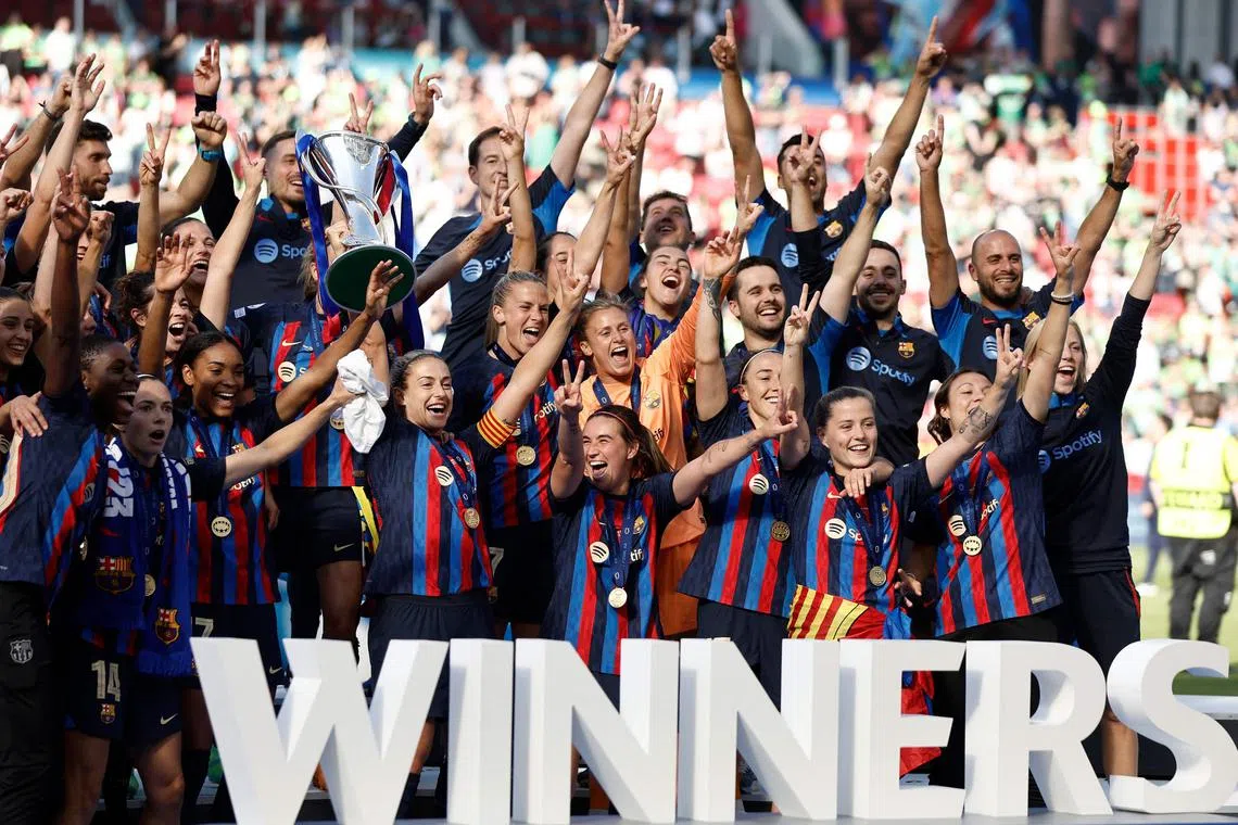 Barcelona team players celebrate their team's victory with the trophy.