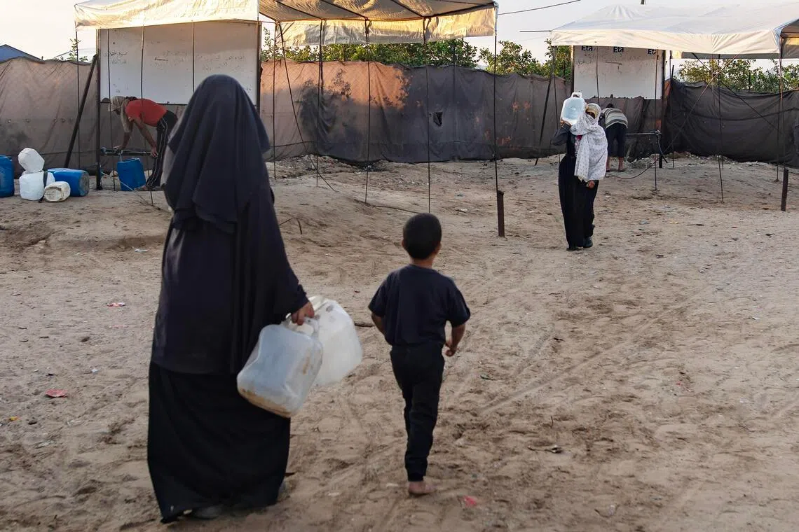 Displaced Palestinians collect water from the Ita charitable water station in Khan Younis, Gaza Strip, on July 13.