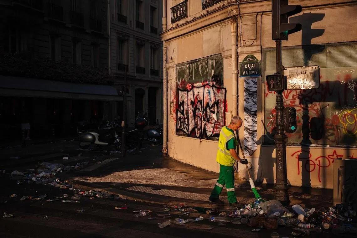 A municipal worker cleaning up food and drink waste near the Canal Saint-Martin on the morning following the national annual street music festival in Paris on June 22.