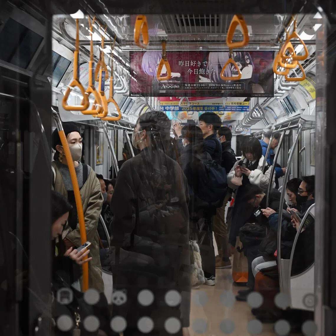 Commuters travel in a train on the JR Yamanote Line, in Tokyo, on Feb 12.