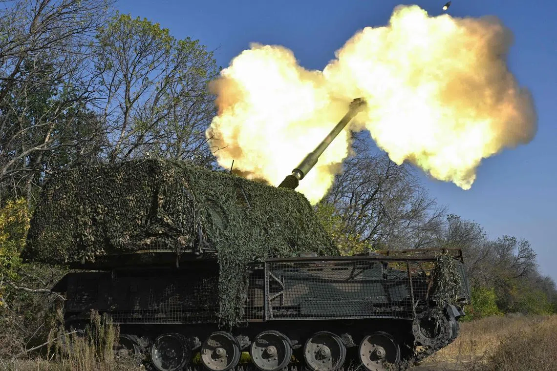 Ukrainian servicemen fire a self-propelled howitzer towards Russian positions in Ukraine's Donetsk region