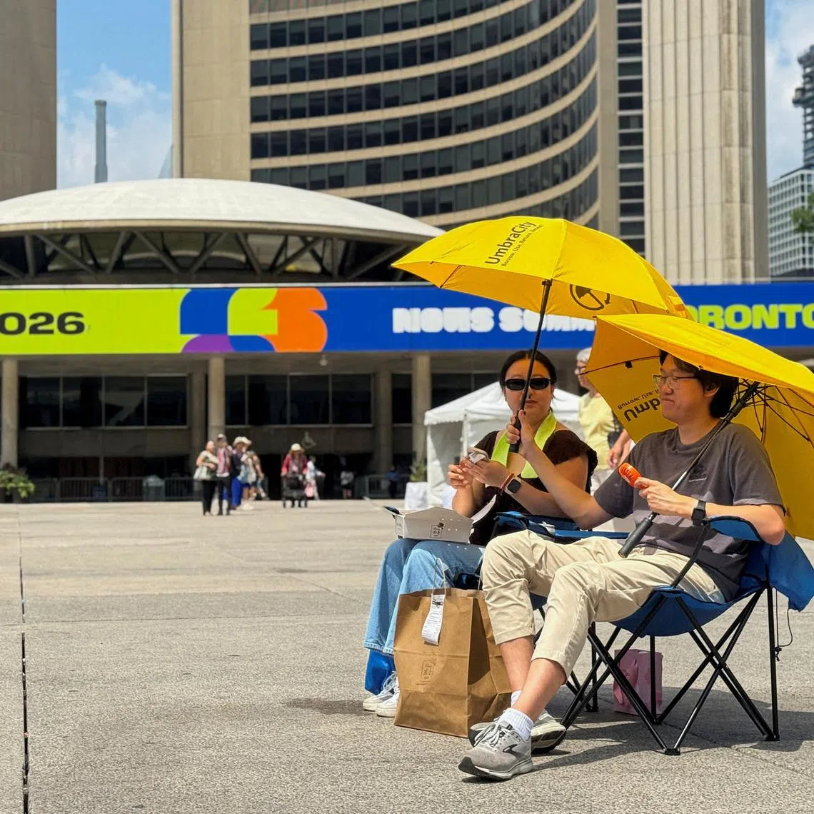 Two football fans watch the match between Ivory Coast and Norway at Nathan Phillips Square in Toronto on June 30.